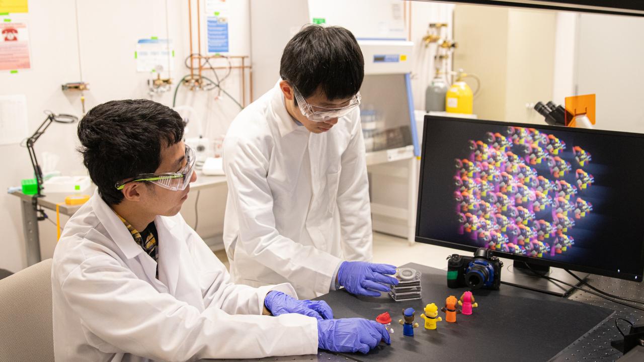 Weijian Yang works with a student in his lab